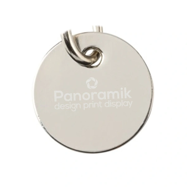 Close-up of a logo laser engraved on the silver back of a trolley coin